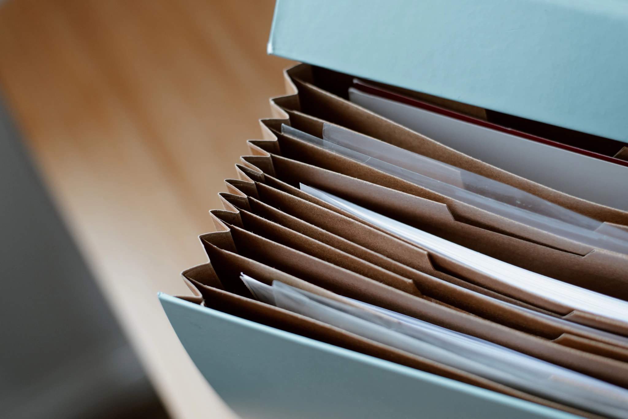An open concertina file, its card dividers separating the documents filed between them.