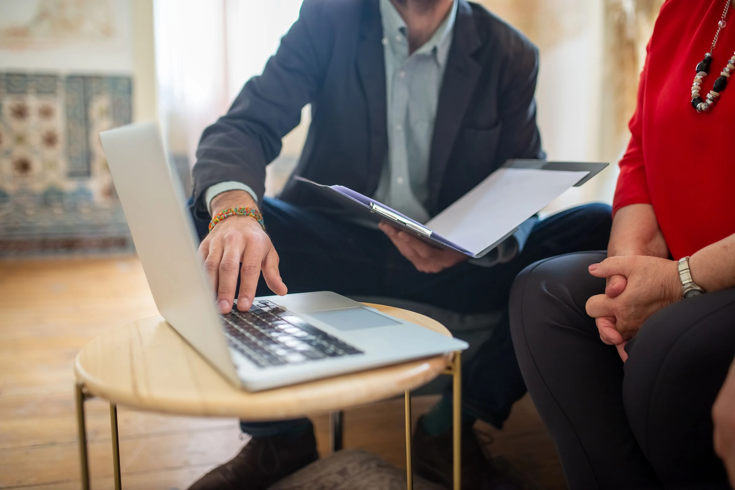 An adviser going through documents on a laptop with a client.